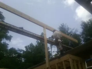 Carpenter setting a ridge beam over a new addition frame — Ice Dam Removal by Roofing Brothers in Index