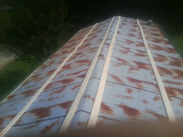 Rusted metal roof panels with new wood purlins before replacement — Storm Damage Roof Repair in Index by Roofing Brothers
