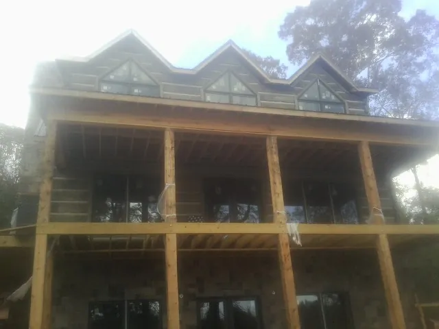 Dormers and porch framing on a large log home under construction — Roof Coating work by our crew in Index