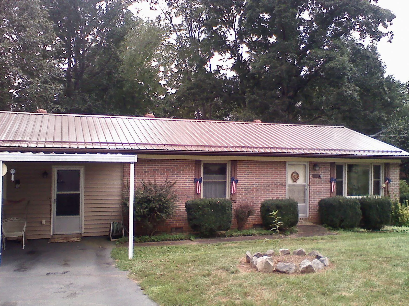 Bronze metal roof and carport on a brick ranch home — Roof Repair work by our crew in Index